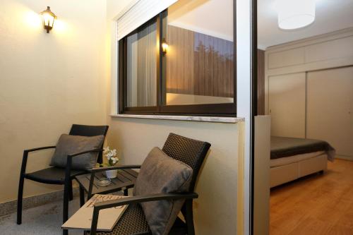 a room with two chairs and a table and a window at Hotel Douro Inn in Tabuaço