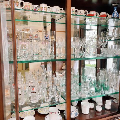 a display case filled with glass glasses and plates at Young House in Matsudo