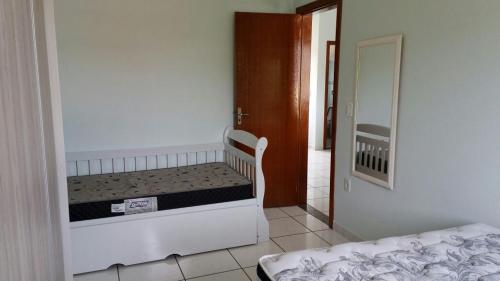 um quarto com 2 camas, um espelho e uma porta em Apartamento 02 em Garopaba