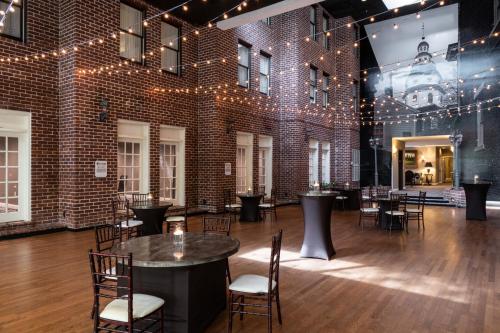 a room with a brick wall and tables and chairs at Historic Inns of Annapolis in Annapolis