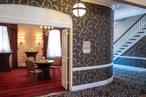 a hotel lobby with a staircase and tables and chairs at Historic Inns of Annapolis in Annapolis