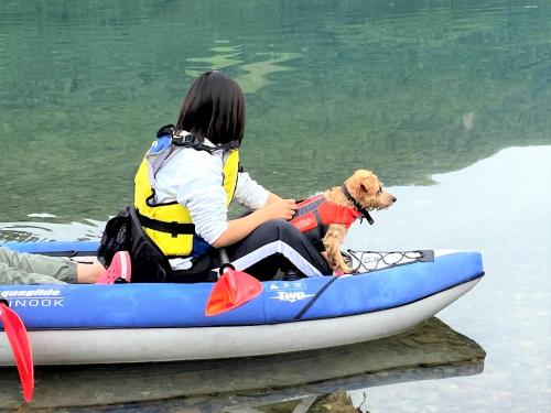 a woman and a dog in a raft on the water at 白馬パウダーマウンテン in Hakuba