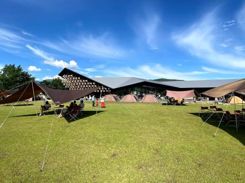a group of tents in a field with grass at 白馬パウダーマウンテン in Hakuba