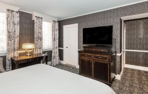 a hotel room with a bed and a flat screen tv at Historic Inns of Annapolis in Annapolis