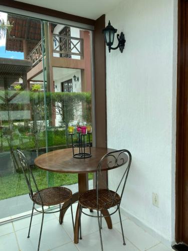 a table and chairs in a room with a window at Chalé Charmoso em Bananeiras no condomínio exclusivo Serra Nevada in Bananeiras