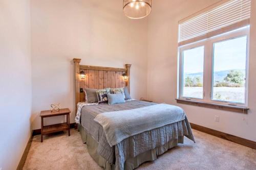 ein Schlafzimmer mit einem großen Bett und einem Fenster in der Unterkunft Moose Willow at Teton Valley Idaho in Victor
