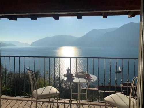 einen Balkon mit einem Tisch, Stühlen und Meerblick in der Unterkunft Belvilla by OYO Belvedere 2 in Marone