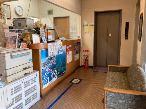 a room with a waiting room with a counter and a table at Business Hotel Chateau Est Takamatsu in Takamatsu