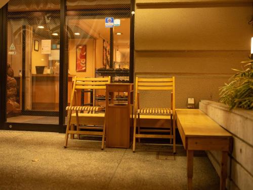 a restaurant with two chairs and a table and a window at Ryokan Hakura in Yamanouchi