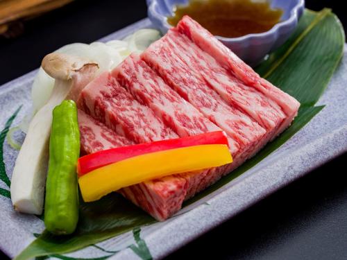 a plate of food with meat and peppers and vegetables at Ryokan Hakura in Yamanouchi