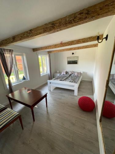 a living room with a bed and a table at Rusnės Pakalnės apartamentai in Rusnė