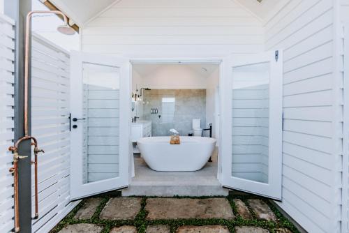 La salle de bains blanche est pourvue d'une baignoire et d'un lavabo. dans l'établissement The Homestead, à Berry