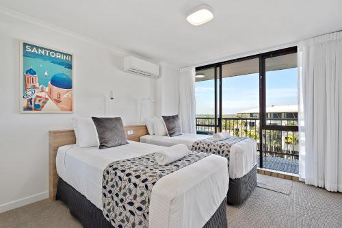 a hotel room with two beds and a balcony at Seaview Resort in Mooloolaba