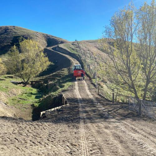 a red truck on a dirt road on a hill at Paratu Farm Cottage in a quiet rural setting. in  Waipukurau