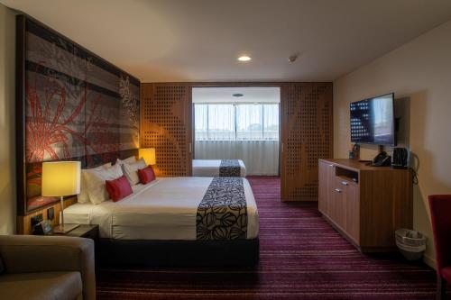 a hotel room with a bed and a flat screen tv at Mantra Gladstone in Gladstone