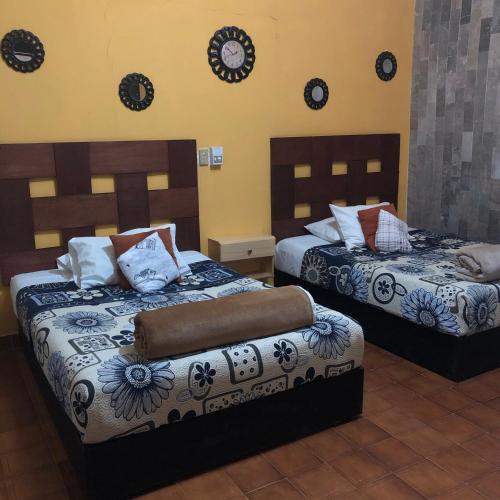 a bedroom with two beds with pillows on them at Hotel Boutique El Sueño del Coronel in Río Verde