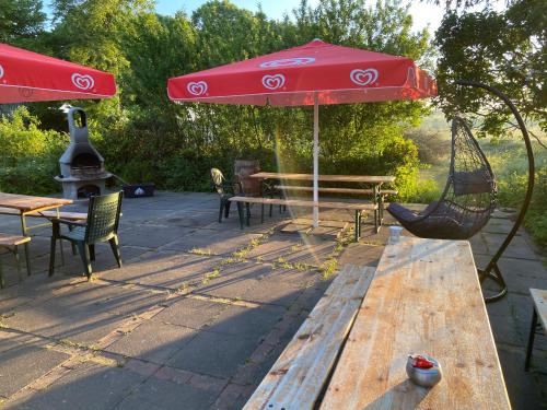 a patio with a hammock and a red umbrella at K 357 - Low budget Hotel in Ratekau bei Lübeck in Ratekau