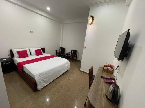 - une chambre avec un lit, une télévision et une table dans l'établissement Senho Hotel, à Hô-Chi-Minh-Ville