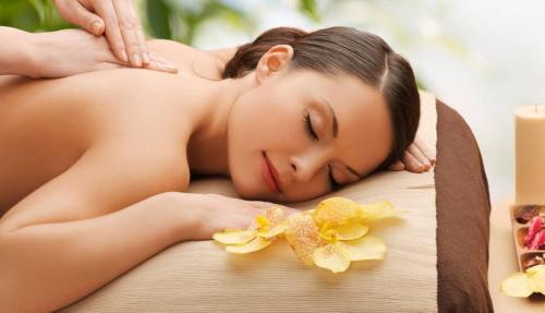 a woman laying on a massage table with flowers at Krishnabalram wellness & Ayurveda centre in Rishīkesh
