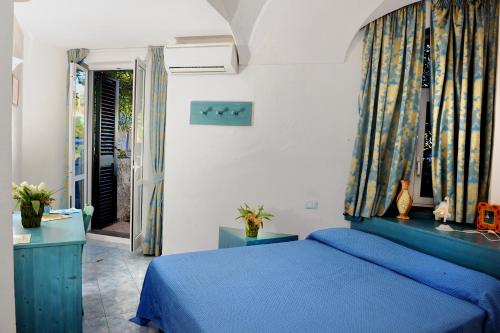 a bedroom with a blue bed in a room at Hotel La Ninfea in Ischia