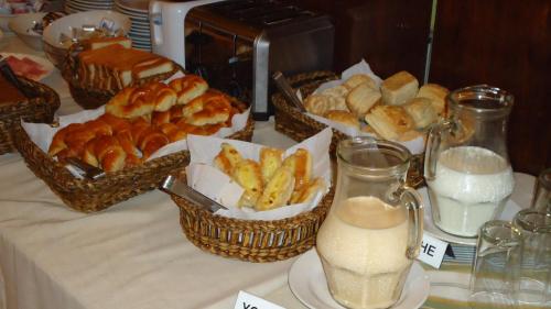 a table with baskets of bread and pastries and a bottle of milk at Hotel Posada Del Sol in Salta