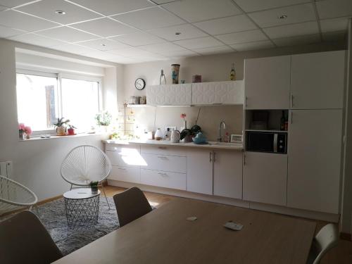 a kitchen with white cabinets and a table in a room at Logement cosy verdoyant RDC avec piscine in Charmes-sur-Rhône