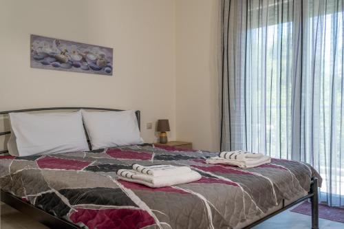 a bedroom with a bed with two towels on it at ANEMOELIA II in Sykia Chalkidikis