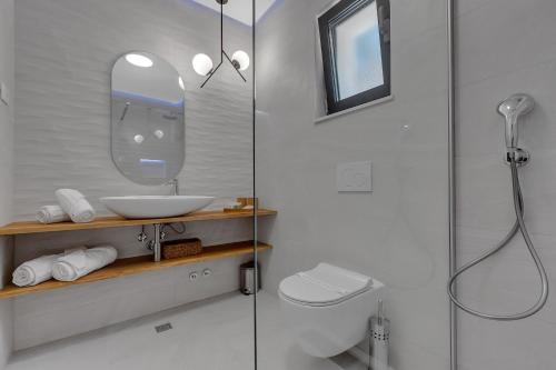 La salle de bains est pourvue de toilettes, d'un lavabo et d'une douche. dans l'établissement Villa Kostela Makarska, à Makarska