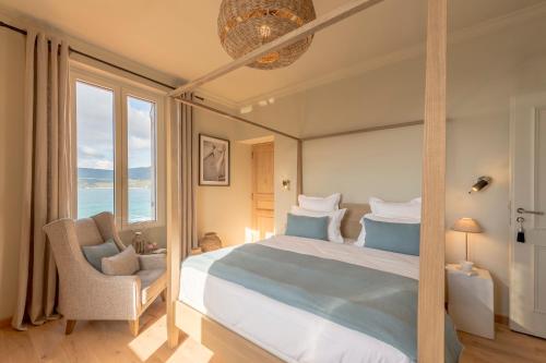 普罗普里亚诺Boutique hôtel Château Rouher的带床、椅子和窗户的卧室