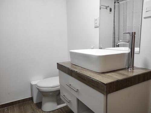 een badkamer met een witte wastafel en een toilet bij EL ENSUEÑO in Lima