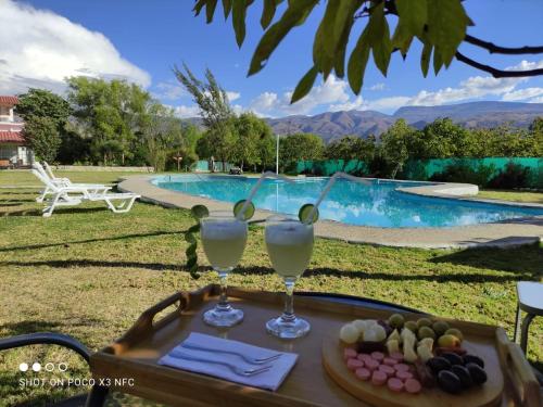 een dienblad met drankjes op een tafel naast een zwembad bij Santa Elena Hotel in Cajabamba
