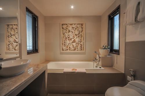 Un baño con bañera, lavabo e inodoro. en Sayang Sanur Terrace House, en Sanur