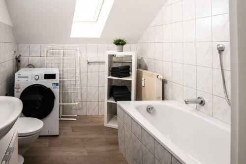 a bathroom with a washing machine and a bath tub at Gemütliche Ferienwohnung im Zentrum von Plauen in Plauen