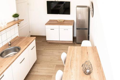 a kitchen with a table and a stainless steel refrigerator at Gemütliche Ferienwohnung im Zentrum von Plauen in Plauen