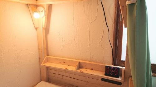 ein Bad mit Licht an der Ecke eines Zimmers in der Unterkunft Kawayu Onsen Guesthouse NOMY in Kawayu