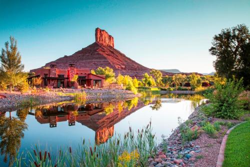 a mountain reflecting in the water in front of a building at Gateway Canyons Resort, a Noble House Resort in Gateway