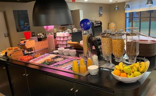 a breakfast buffet with fruit and other food on a counter at Campanile Bordeaux Ouest - Mérignac Aéroport in Mérignac