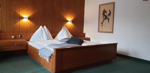 a bed in a room with two lights on the wall at Hotel Schönbrunn in Merano