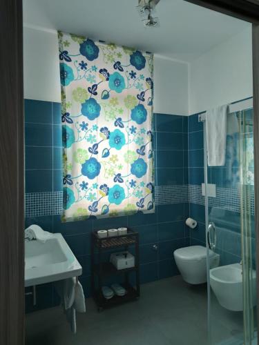 a blue bathroom with a toilet and a sink at Tenuta Santa Maria in Mattinata