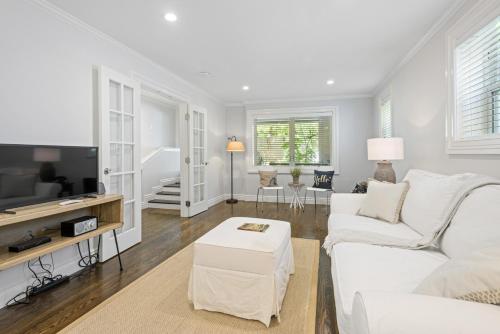 a living room with a white couch and a tv at Garden Level Flat in 1885 Queen Anne Victorian Cottage in Alameda in Alameda