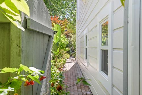 an alleyway next to a house with a fence at Garden Level Flat in 1885 Queen Anne Victorian Cottage in Alameda in Alameda