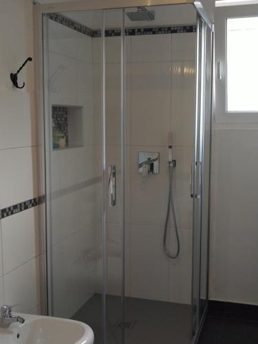 una ducha con una puerta de cristal junto a un lavabo en Apartma Javoršček, en Bovec