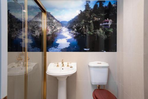 łazienka z umywalką, toaletą i obrazem w obiekcie Fitzpatricks Inn w mieście Westbury
