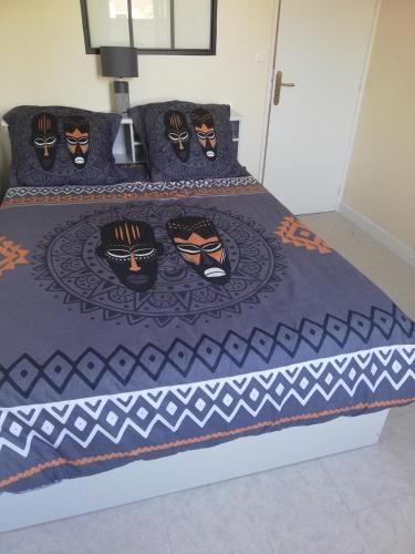 - un lit avec un couvre-lit et des visages dans l'établissement Joli appartement résidentiel à Troyes, à Troyes