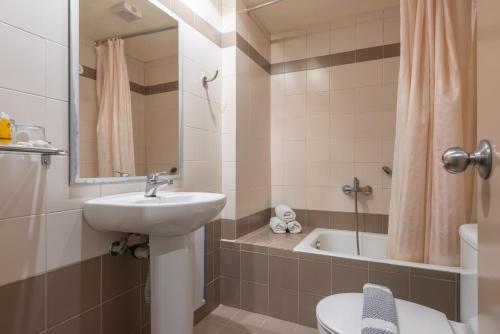 a bathroom with a sink and a toilet and a tub at Yria Hotel in Zakynthos Town