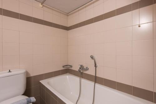 a bathroom with a bath tub and a toilet at Yria Hotel in Zakynthos Town
