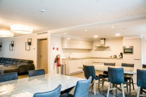 a kitchen and a living room with a table and chairs at De Zwaluwhoeve in Peer