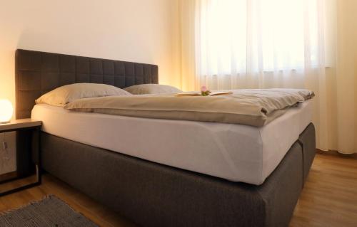 ein großes Bett in einem Zimmer mit Fenster in der Unterkunft Papillon i Dolce Vita in Tar