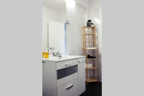 ein weißes Badezimmer mit einem Waschbecken und einem Spiegel in der Unterkunft Precioso Apartamento Los Álamos Playa Golf in Torremolinos