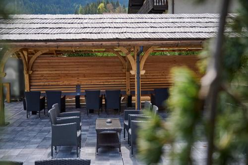 a patio with chairs and tables and a pavilion at Guesthouse S in Luče